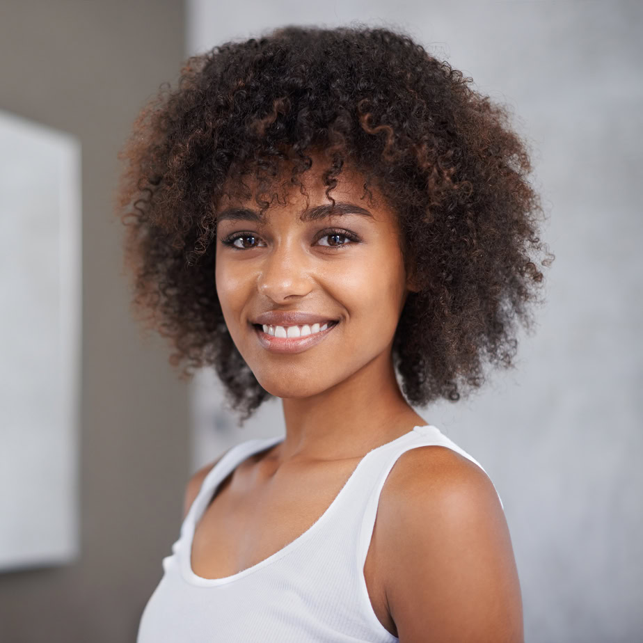african-woman-portrait-happy-bathroom-beauty-wellness-afro-home-start-morning-routine-girl-person-happy-with-cosmetics-change-transformation-with-hair-apartment Beautiful young African-American woman smiling.
