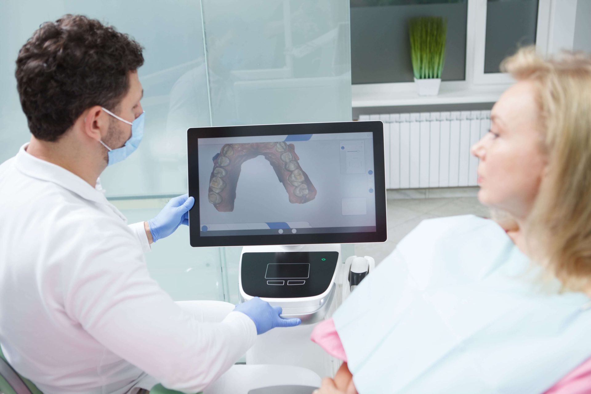 Dentist looking at details of intraoral scan with patient chair side