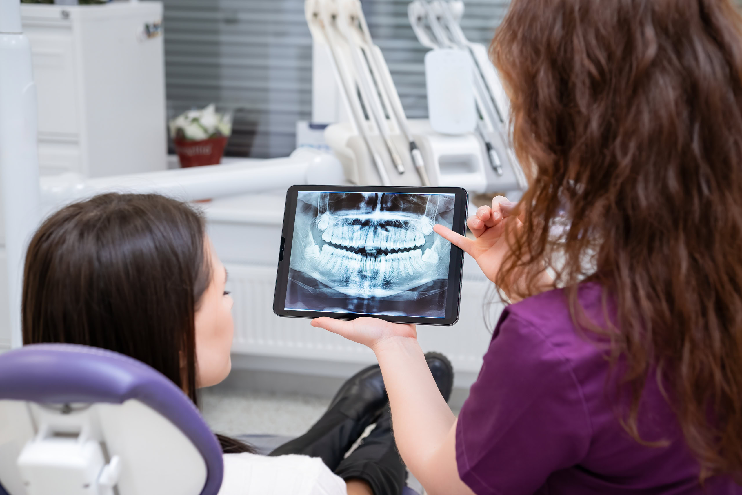 Dentist reviewing X-rays with patient on tablet