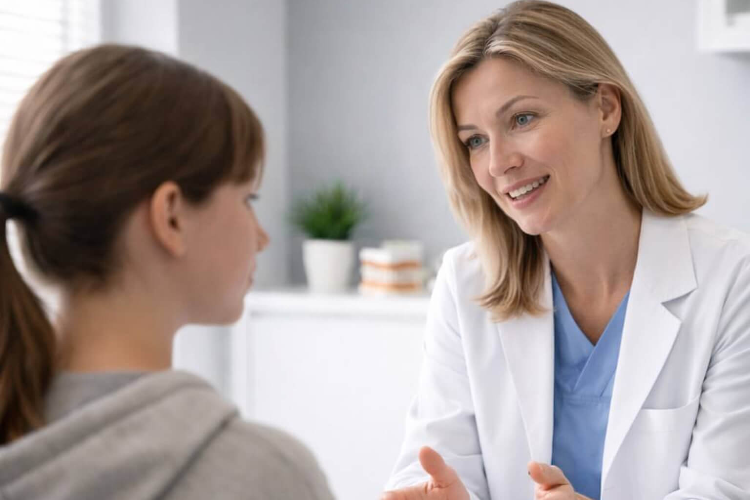 Female doctor talking to young female patient in a medical consultation.