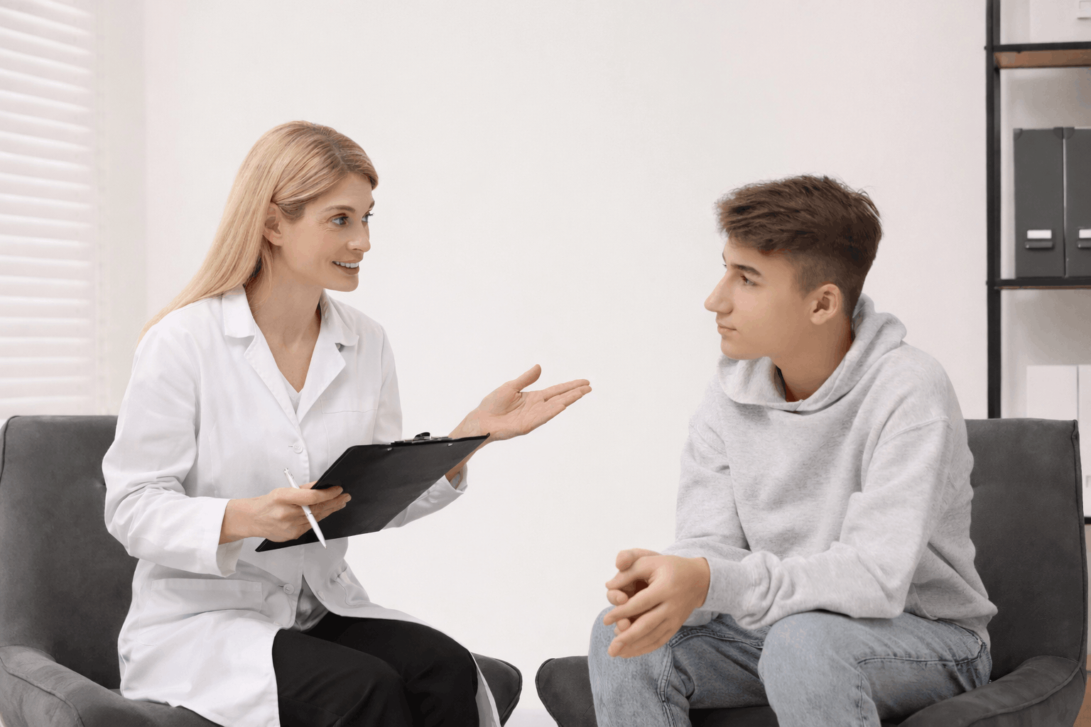 Doctor discussing genioplasty options with a young male patient.