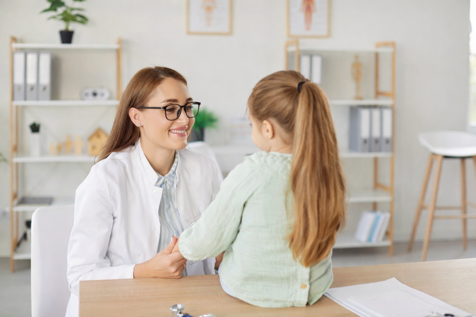 Doctor consulting with young girl in a medical office about facial treatment.