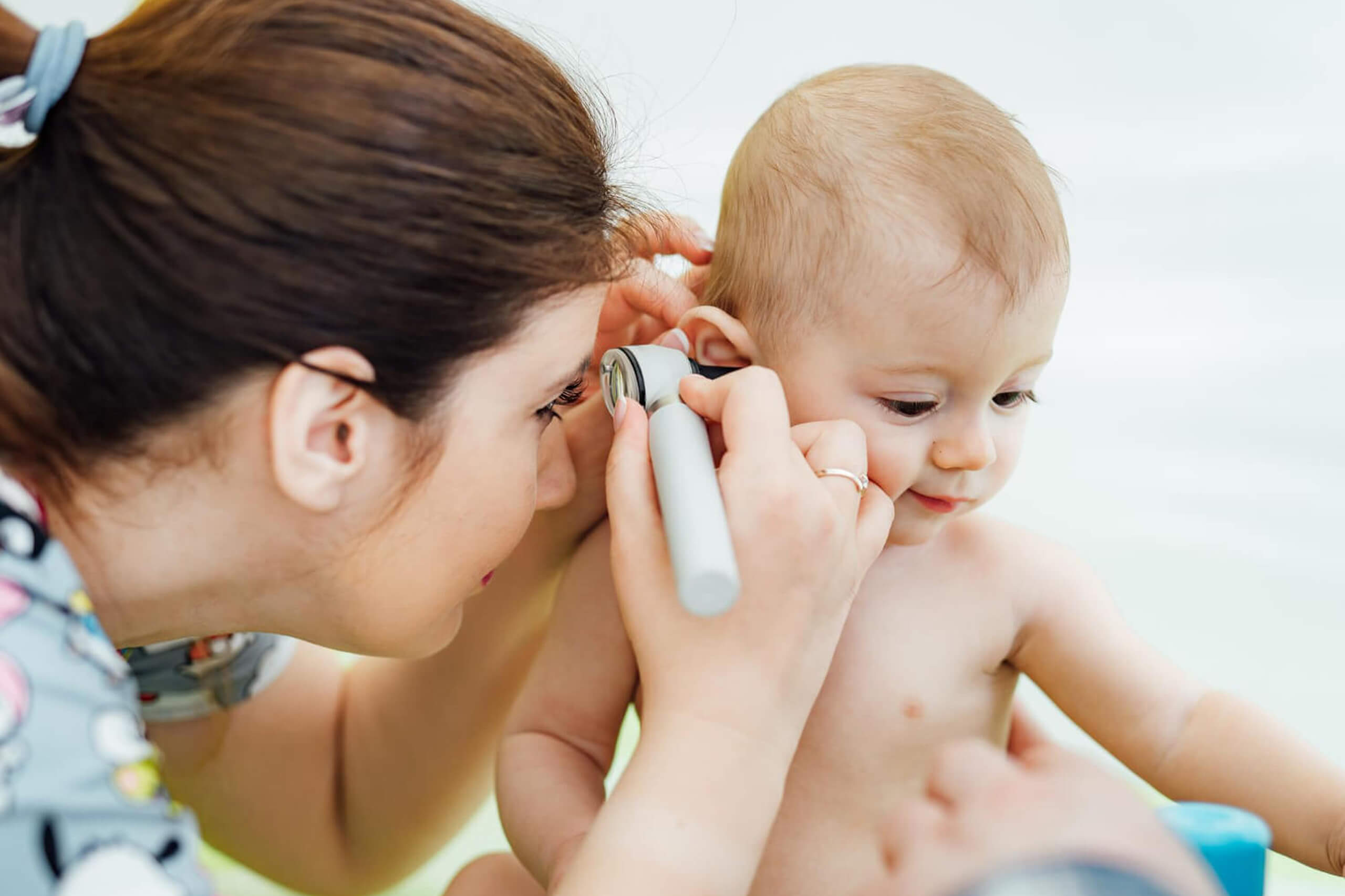 Woman pediatrician is examining little baby.
