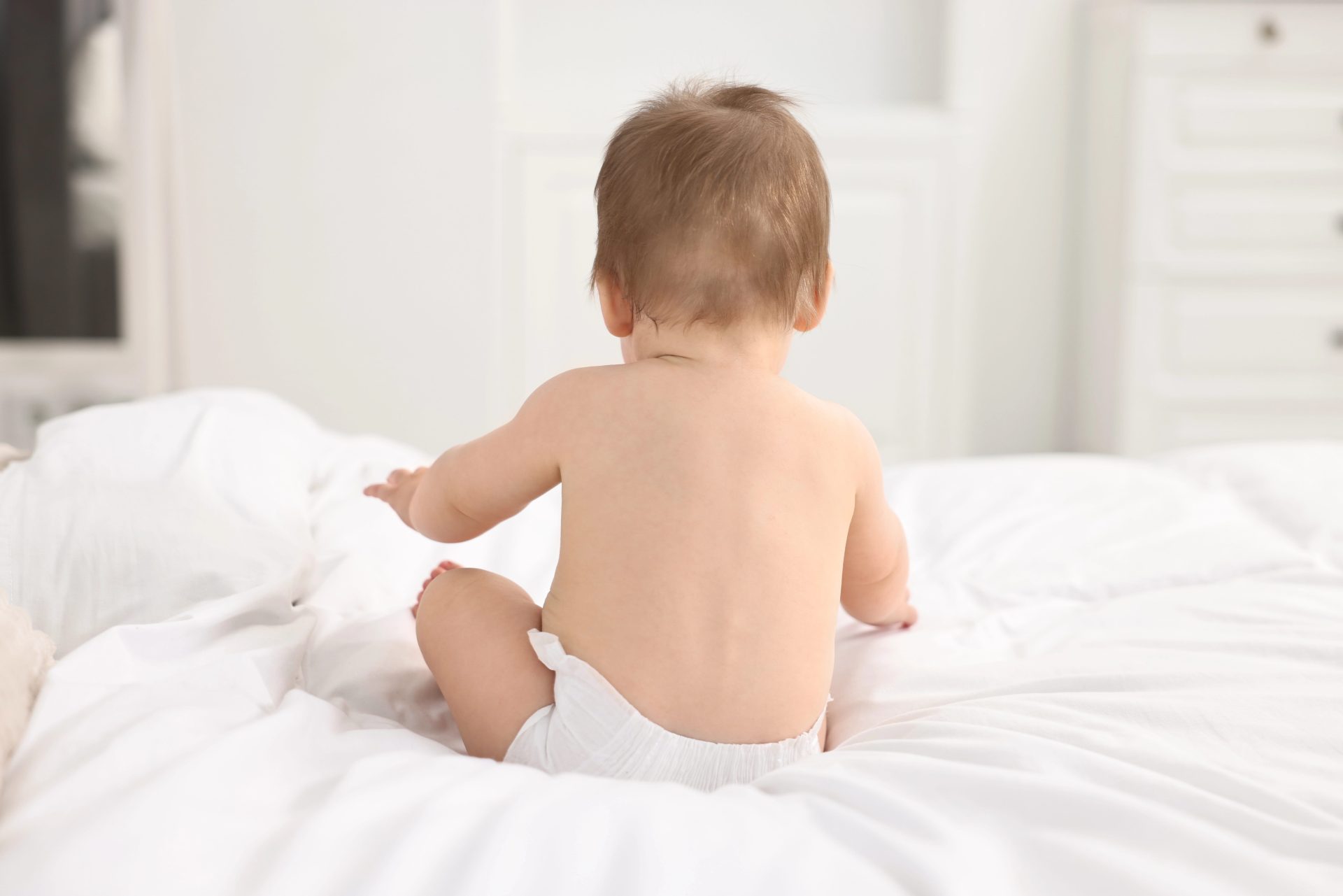 Depositphotos_724115598_XL-min Young child sitting on a bed