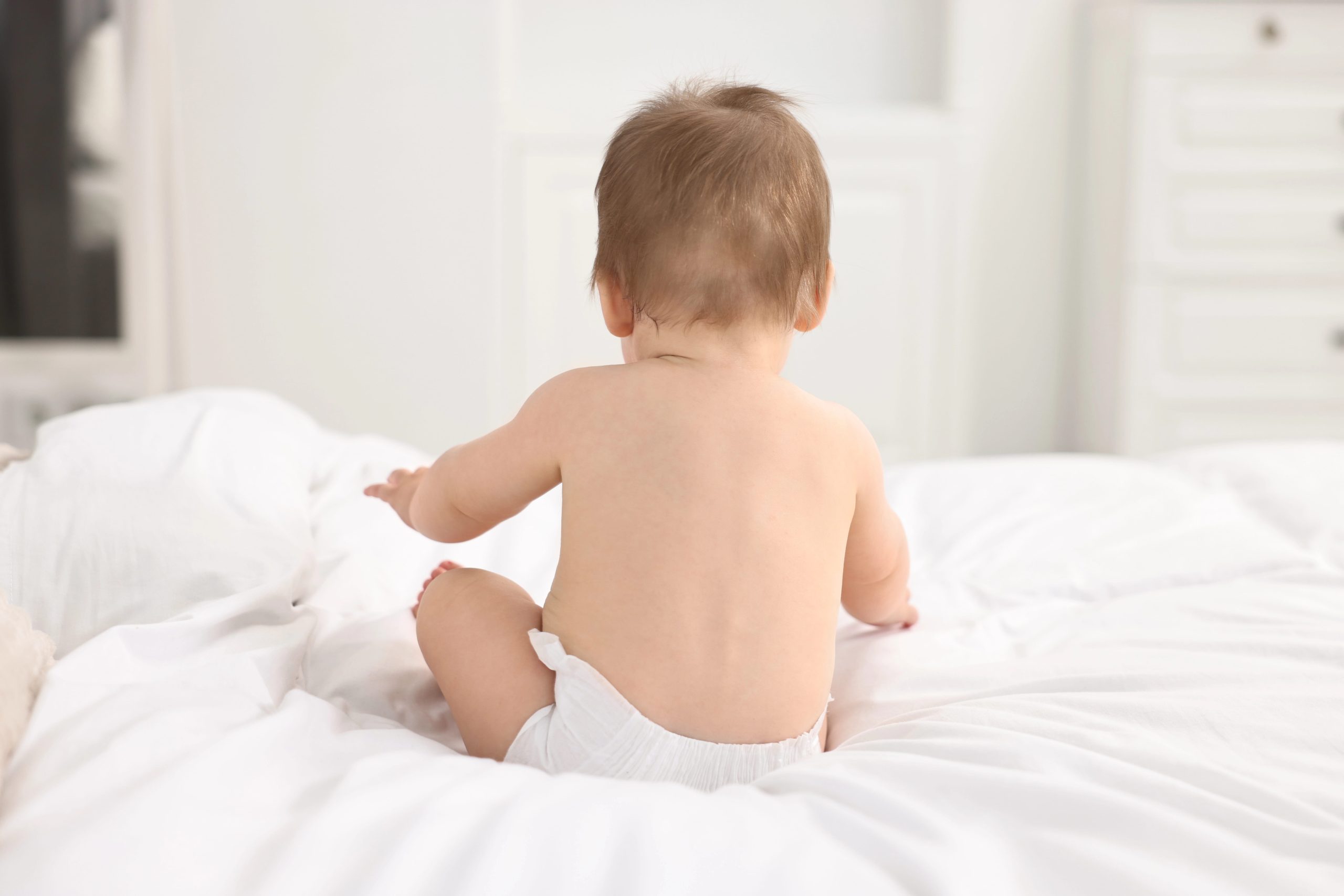 Young Child Sitting On Bed