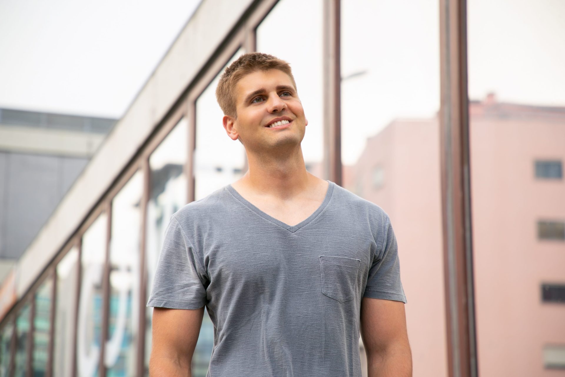 happy-well-built-caucasian-guy-waiting-someone-min Young man smiling outdoors