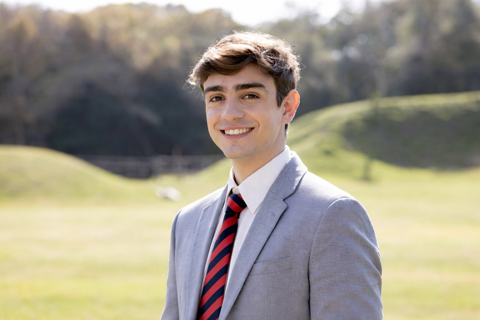 close-up-smiling-worker-grey-suit-white-shirt Young man with maxillary hypoplasia in jacket and tie smiling